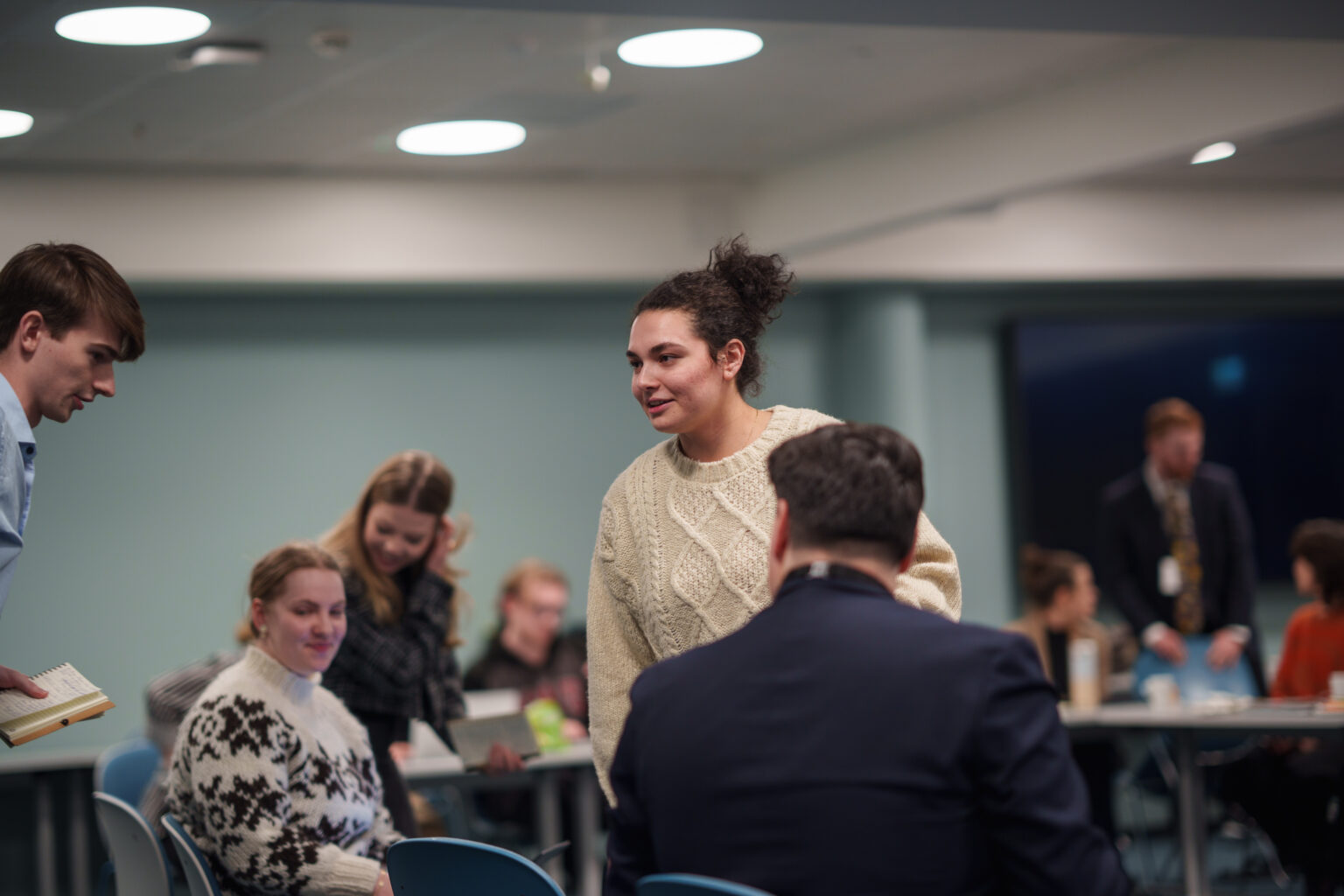 Arctic Frontiers - A group of people having a discussion in a modern, brightly lit meeting room during the Arctic Frontiers - 2025 conference Student forum.