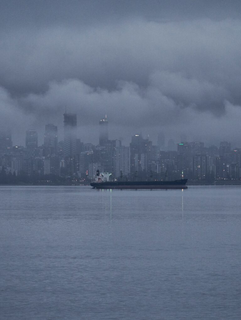 Foggy cityscape with ship on water